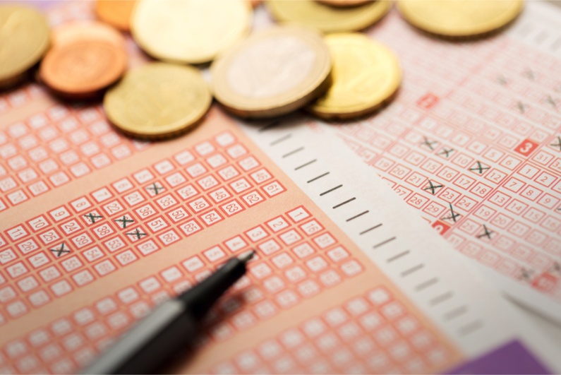 Lottery tickets with coins and pen